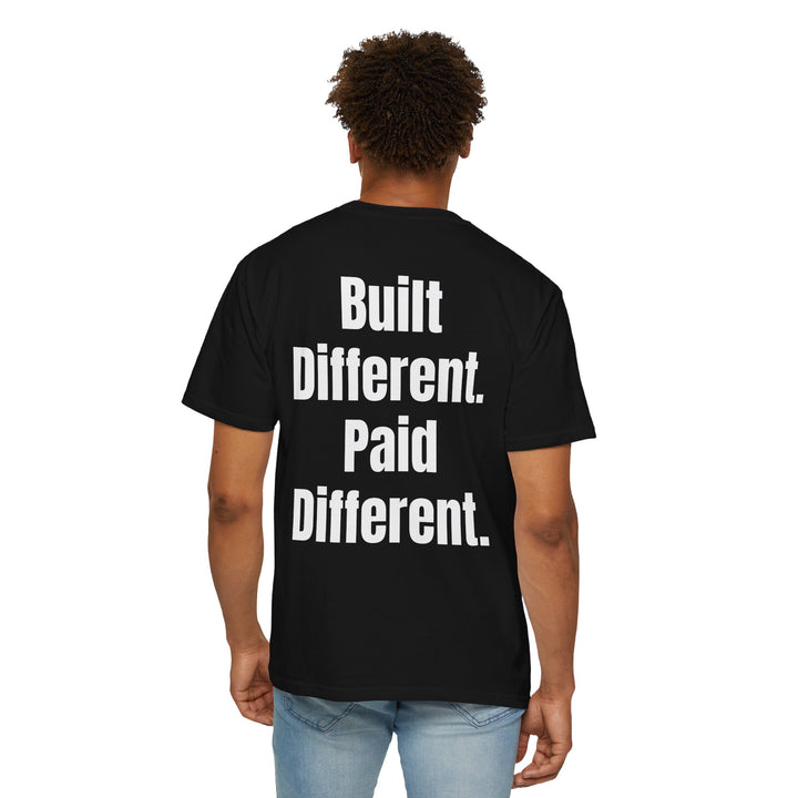 Unisex "Built Different, Paid Different" motivational t-shirt in garment-dyed fabric, offering relaxed fit and unique texture for a stylish, comfortable everyday look.
