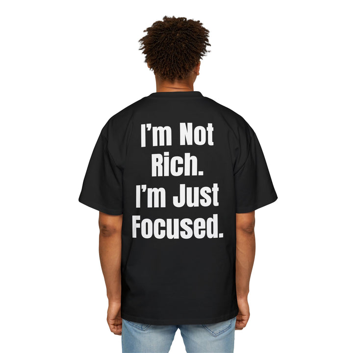 Men's oversized black cotton t-shirt with bold white text reading "I'm Not Rich. I'm Just Focused." and dropped shoulder fit.